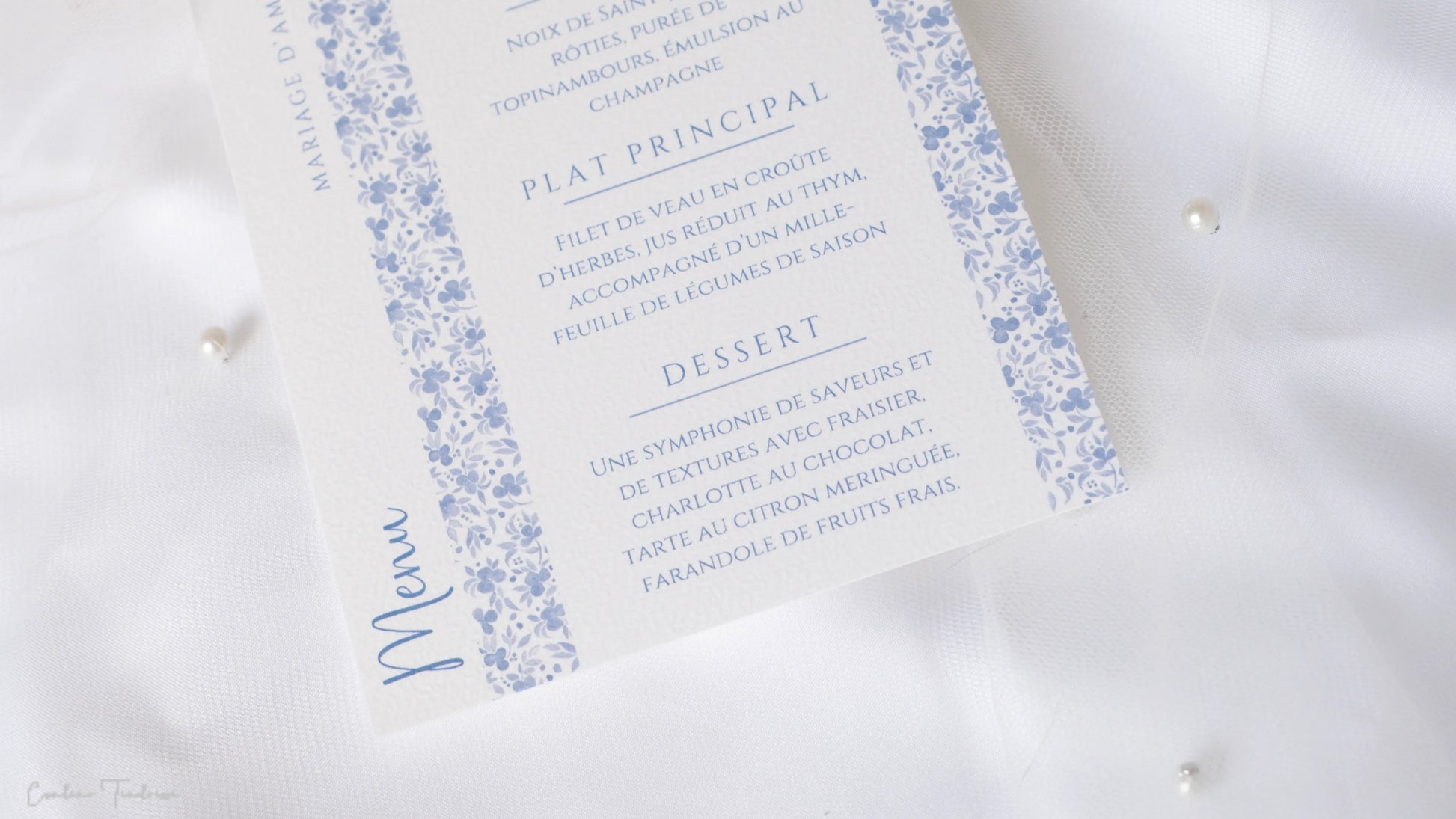 Menu mariage raffiné imprimé sur papier texturé blanc, motifs floraux bleus délicats
